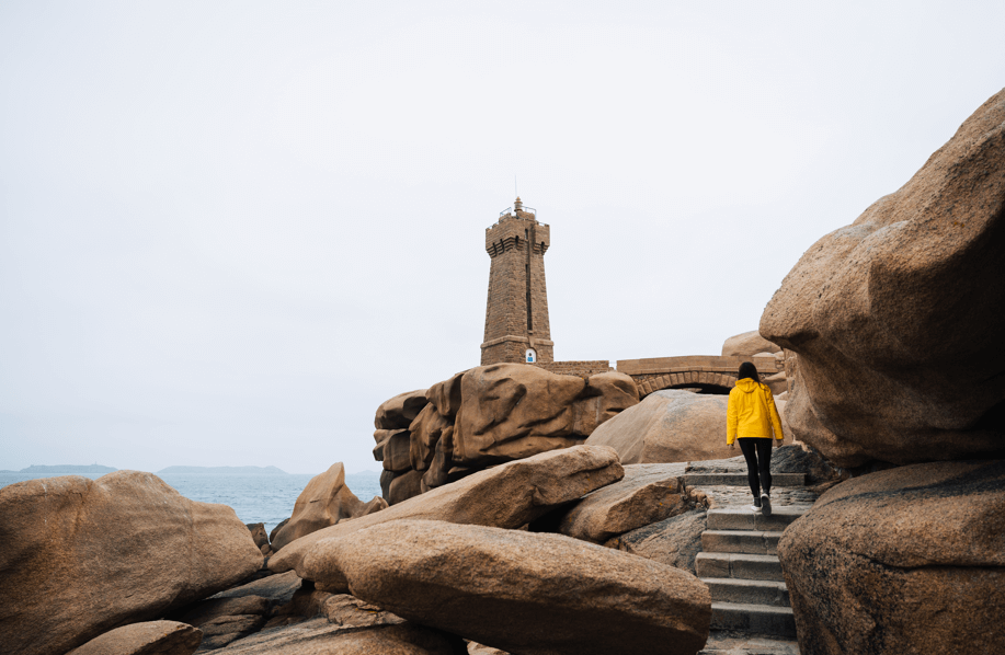 Photo du phare de Mean Ruz sur la Côte de Granit Rose avec une randonneuse qui s'y rend