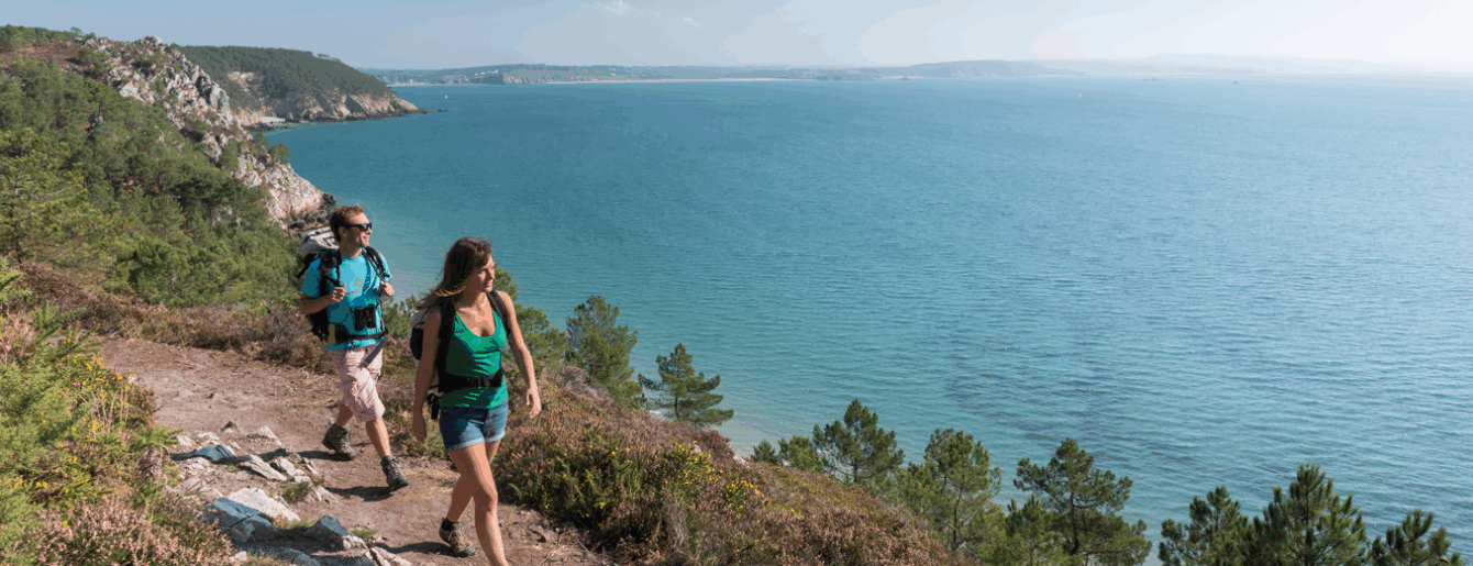 Randonneurs sur le sentier des Douaniers marchant et admirant la vue