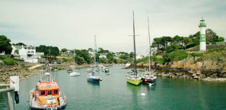 Bateaux à voile et vedettes dans le chenal du port de Doëlan entre les deux phares