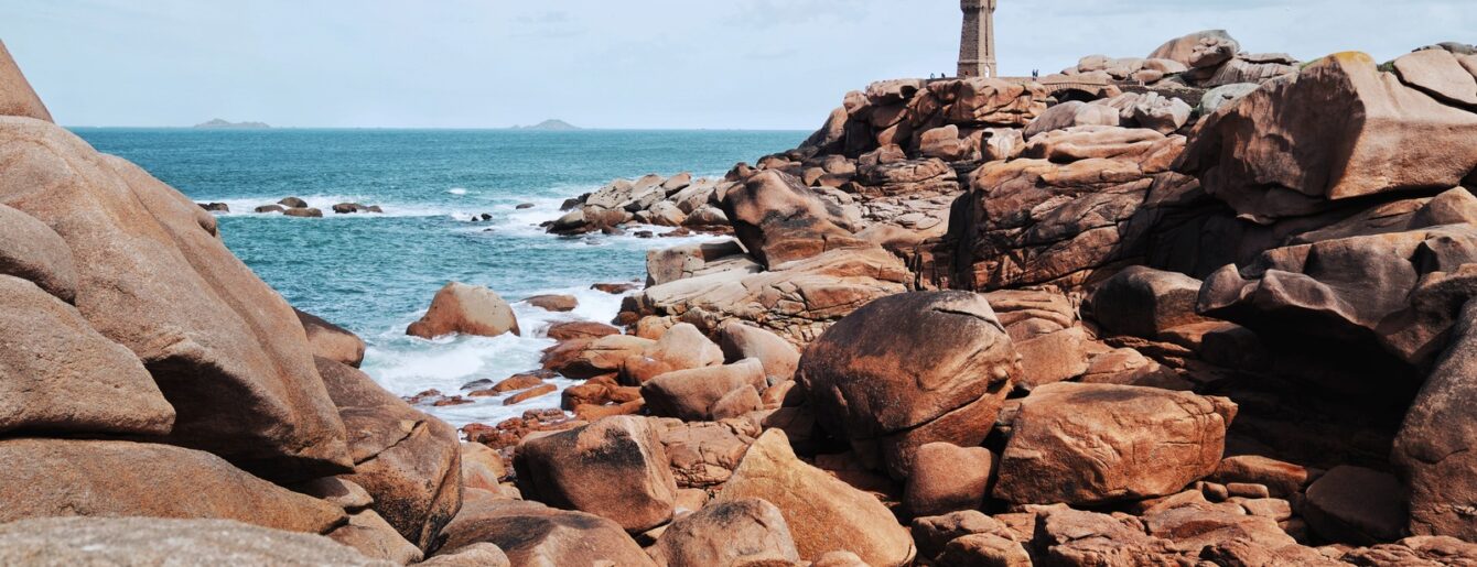 Vue sur le phare de Ploumanac’h entouré de rochers de granit rose en Bretagne
