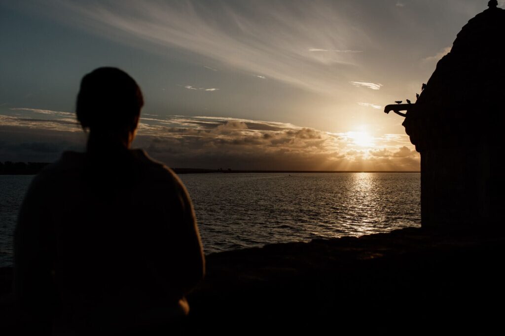 Silhouette face au coucher de soleil sur la baie du Mont-Saint-Michel, lumière dorée sur la mer