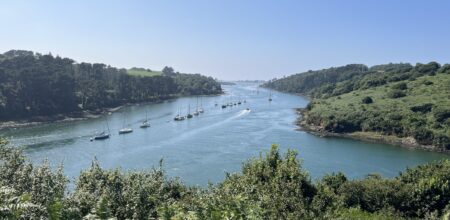 Aber breton serpentant entre collines verdoyantes avec voiliers.