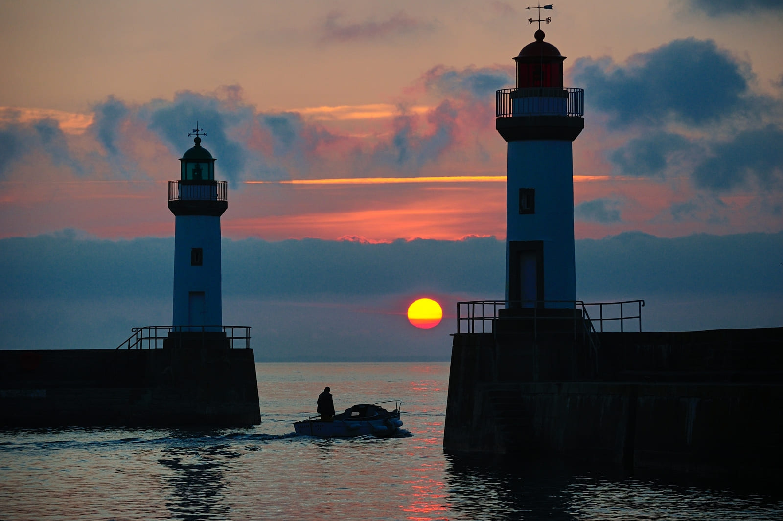 Coucher de soleil entre les deux phares du port du Palais 